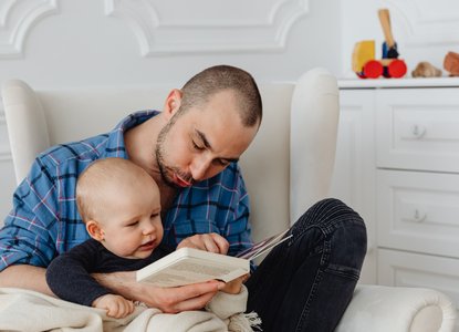 baby reading with dad