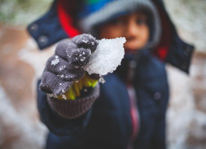 Child holding snow