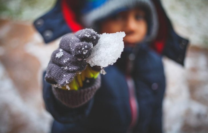 Child holding snow