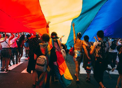 People under a Pride flag
